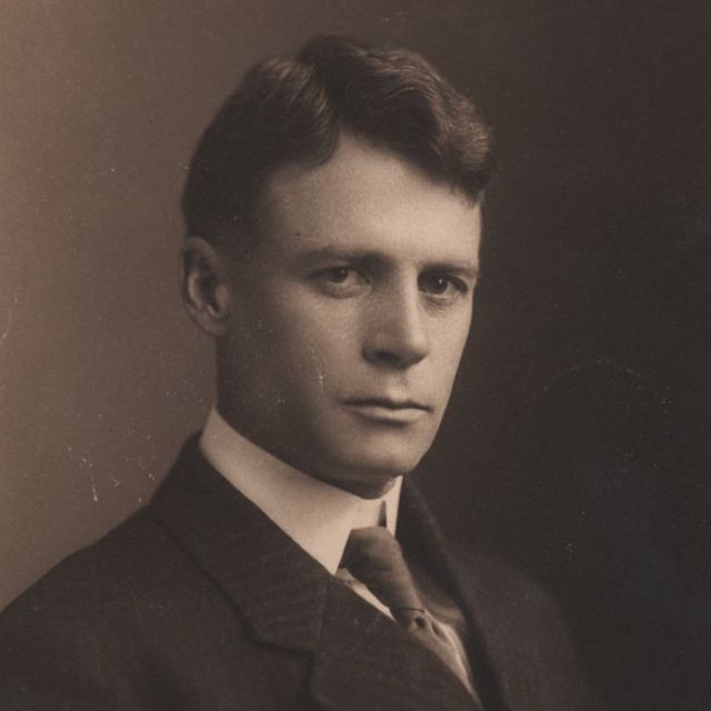 Sepia toned photo of Dr. Howard Taylor Ricketts in suit and tie, straight-faced, against a blank backdrop